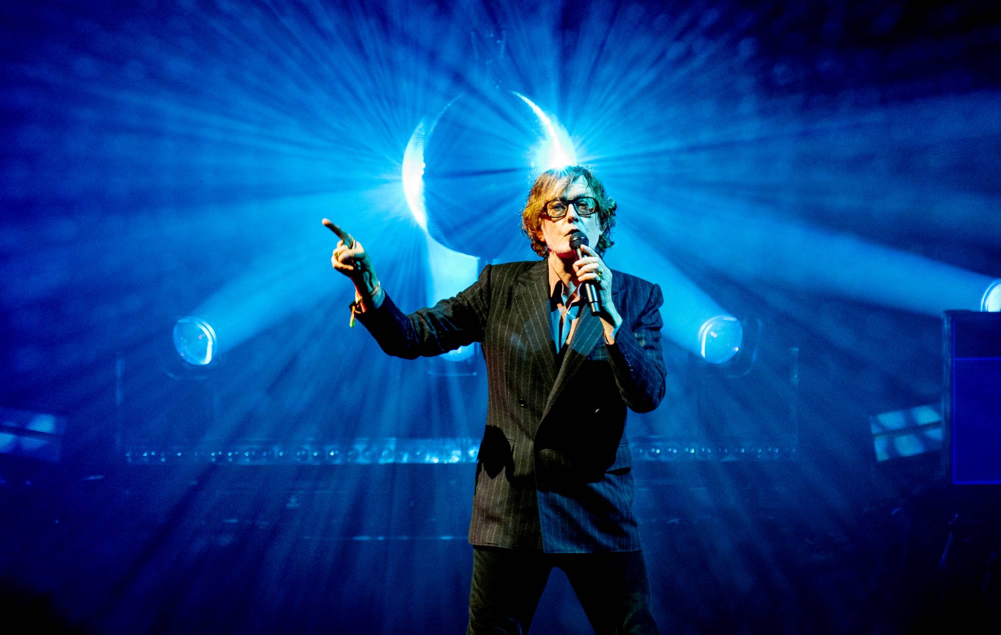 Jarvis Cocker performing on stage with Pulp at a festival