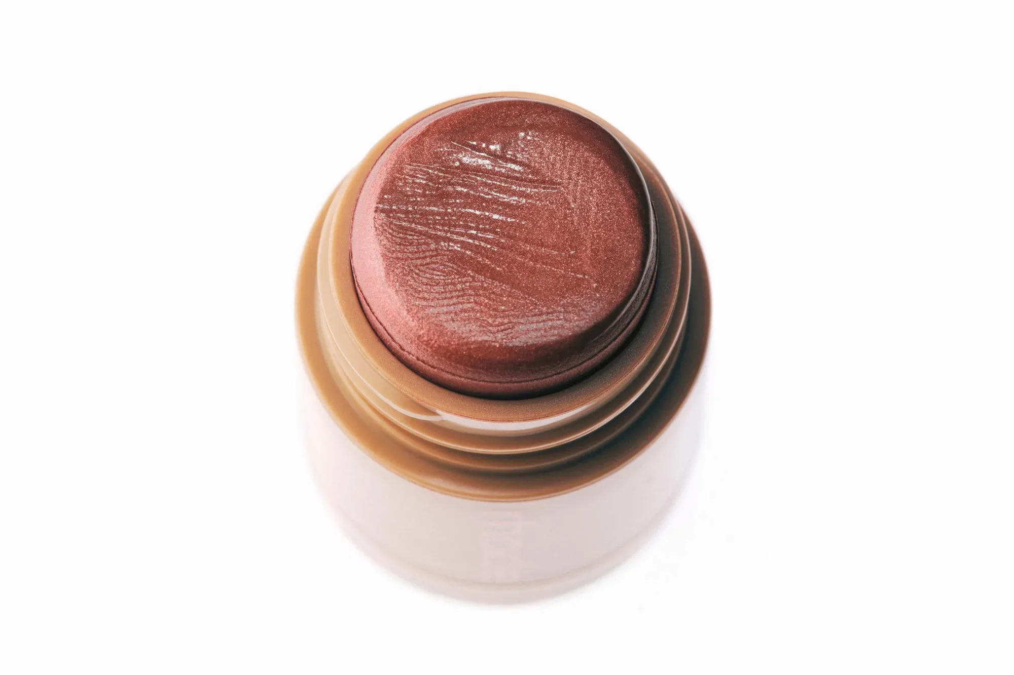 Top-down view of an open tube of dark pink cream blush with a shimmery finish.