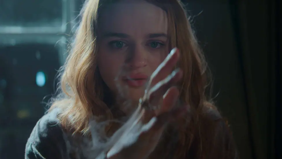 Joey King portraying Sally’s daughters Kylie. She is looking at her hand which is outstretched as a mist is wafting off of it.