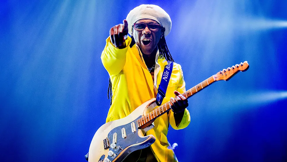 Nile Rodgers attending a red carpet event with his guitar