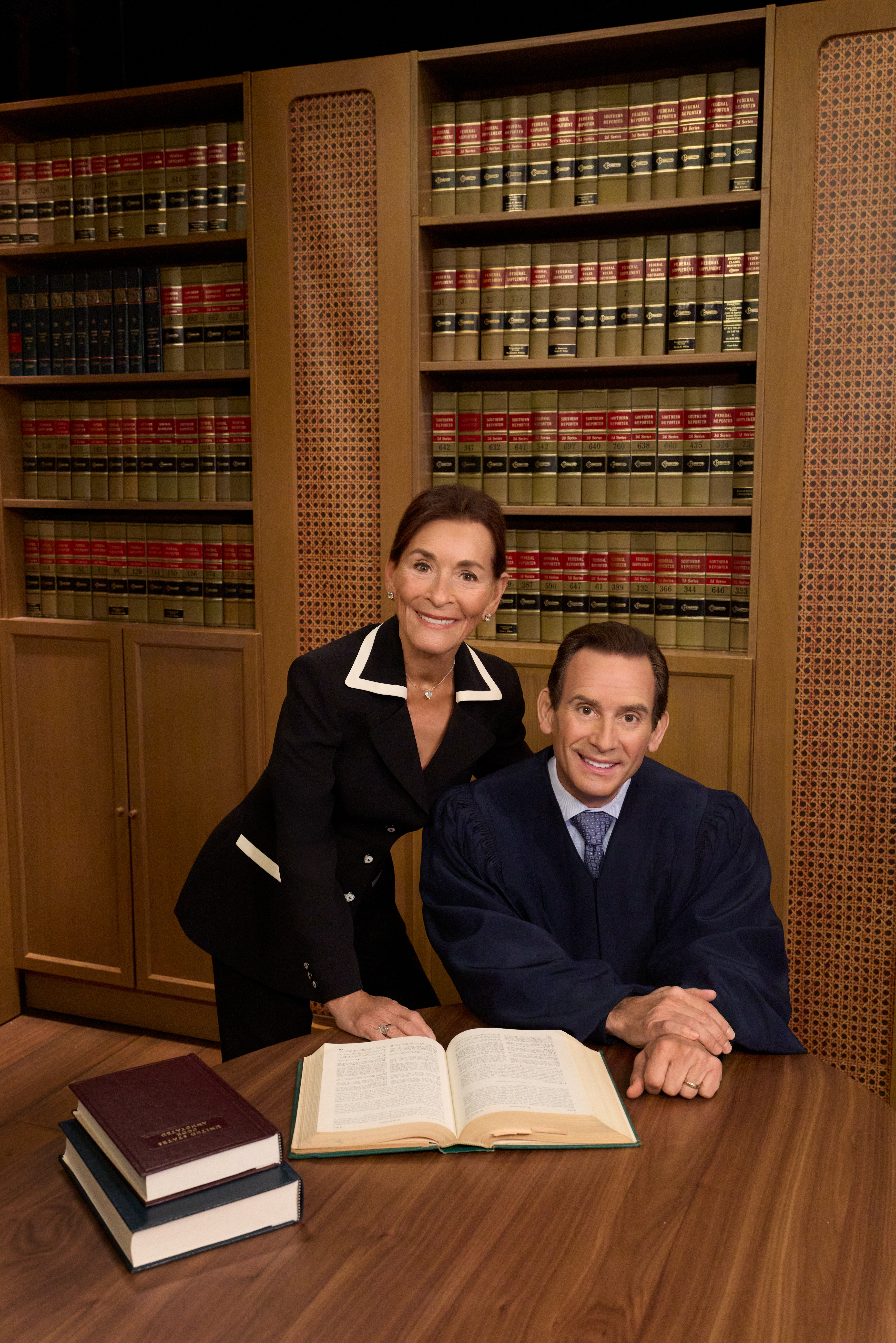 Judge Judy Sheindlin stands behind Adam Levy, dressed in a judge
