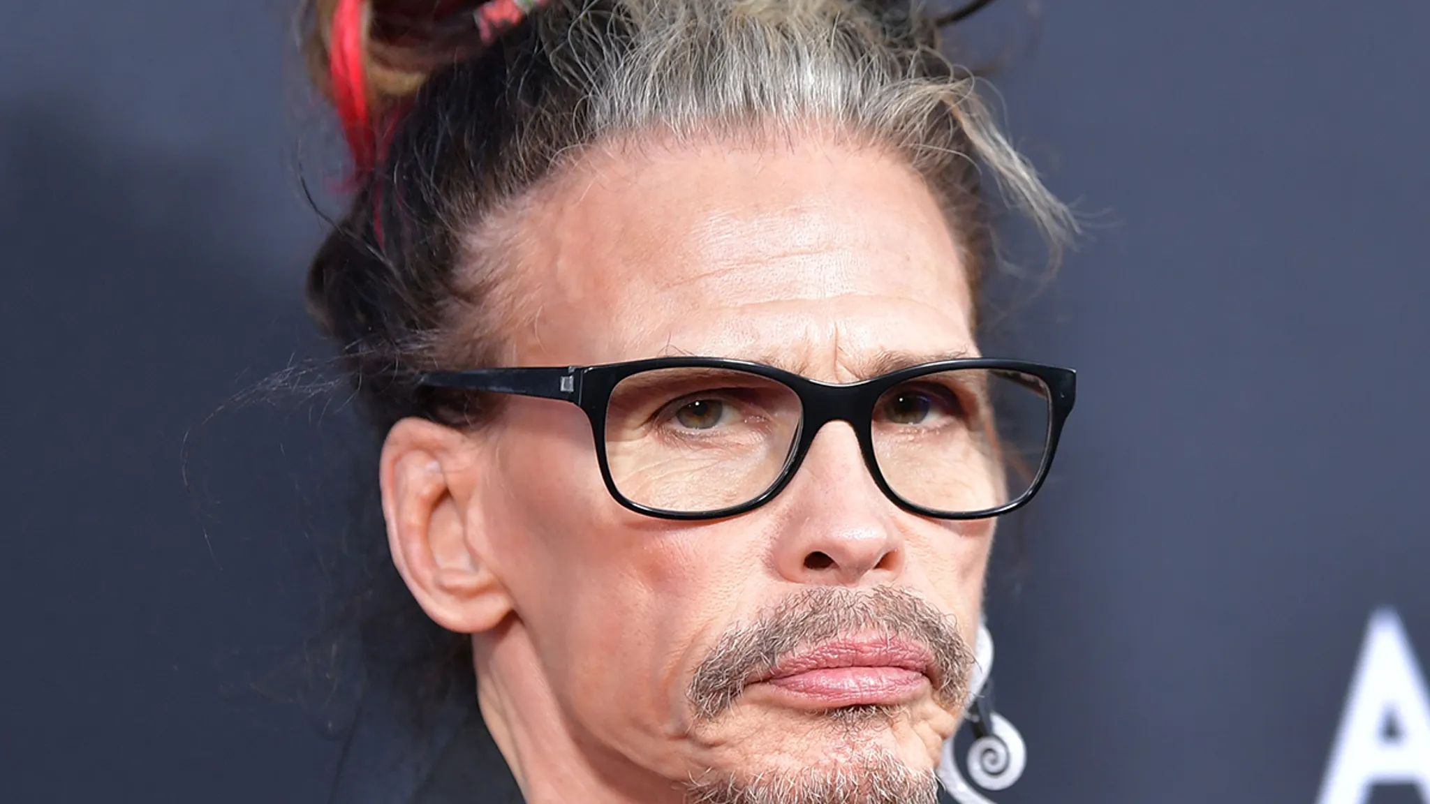 Steven Tyler of Aerosmith singing into a microphone on stage