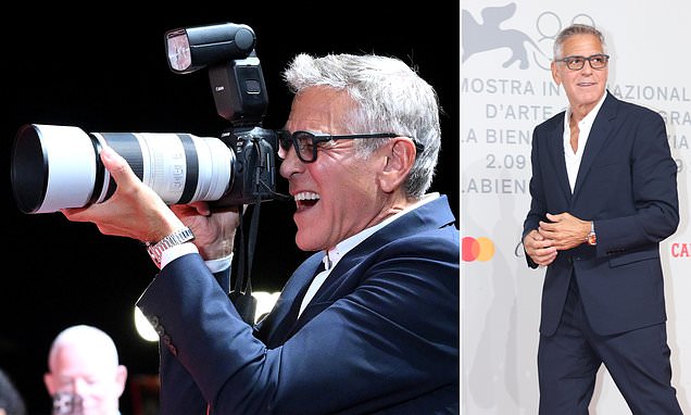 George Clooney smiling and posing at a major film festival red carpet