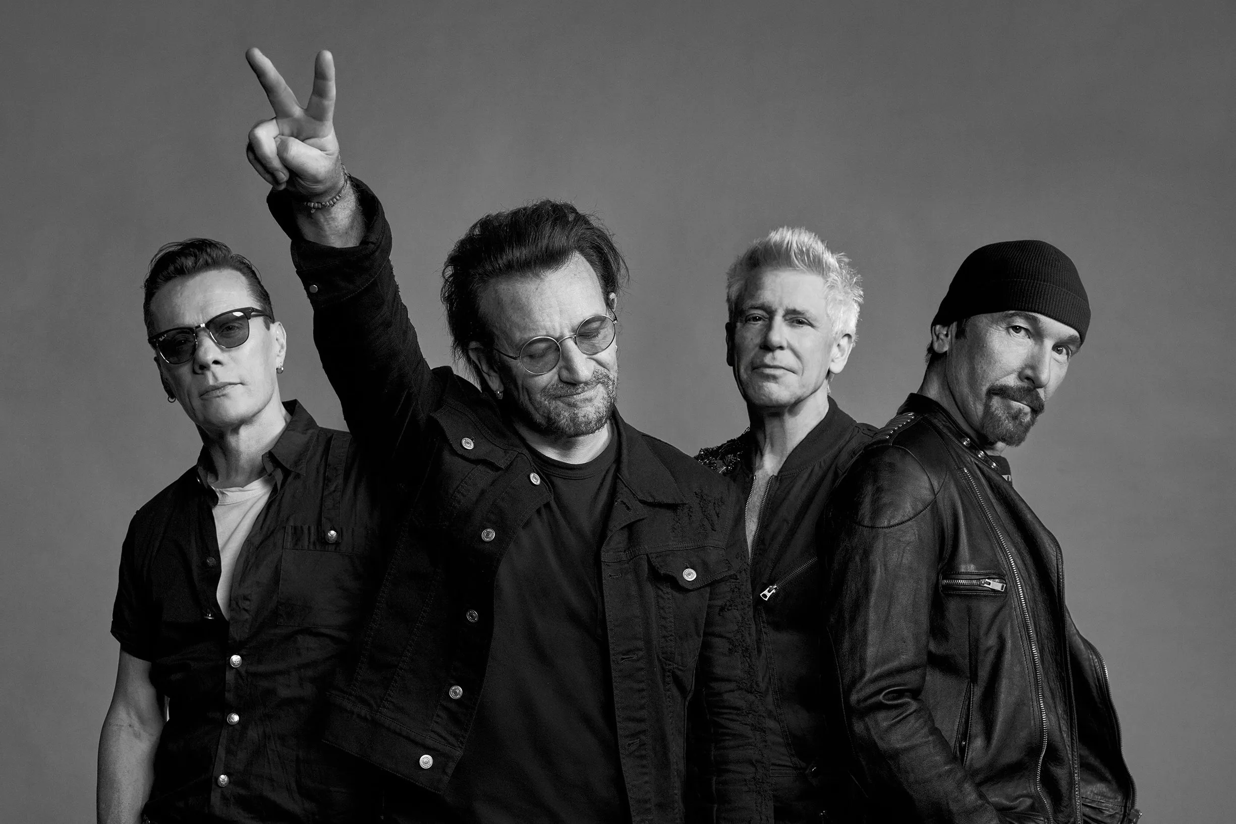 Members of rock band U2 standing together at an event