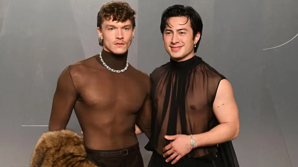 Connor Storrie and Hudson Williams attend the 2026 Vanity Fair Oscar party in LA, they are both wearing sheer chiffon black tops.