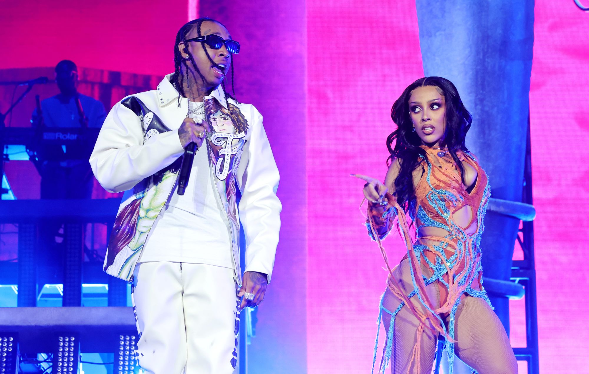 Tyga performing live on stage under blue concert lights