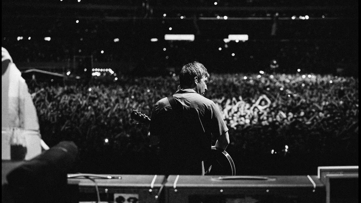 Noel Gallagher performing on stage during the Oasis reunion tour.