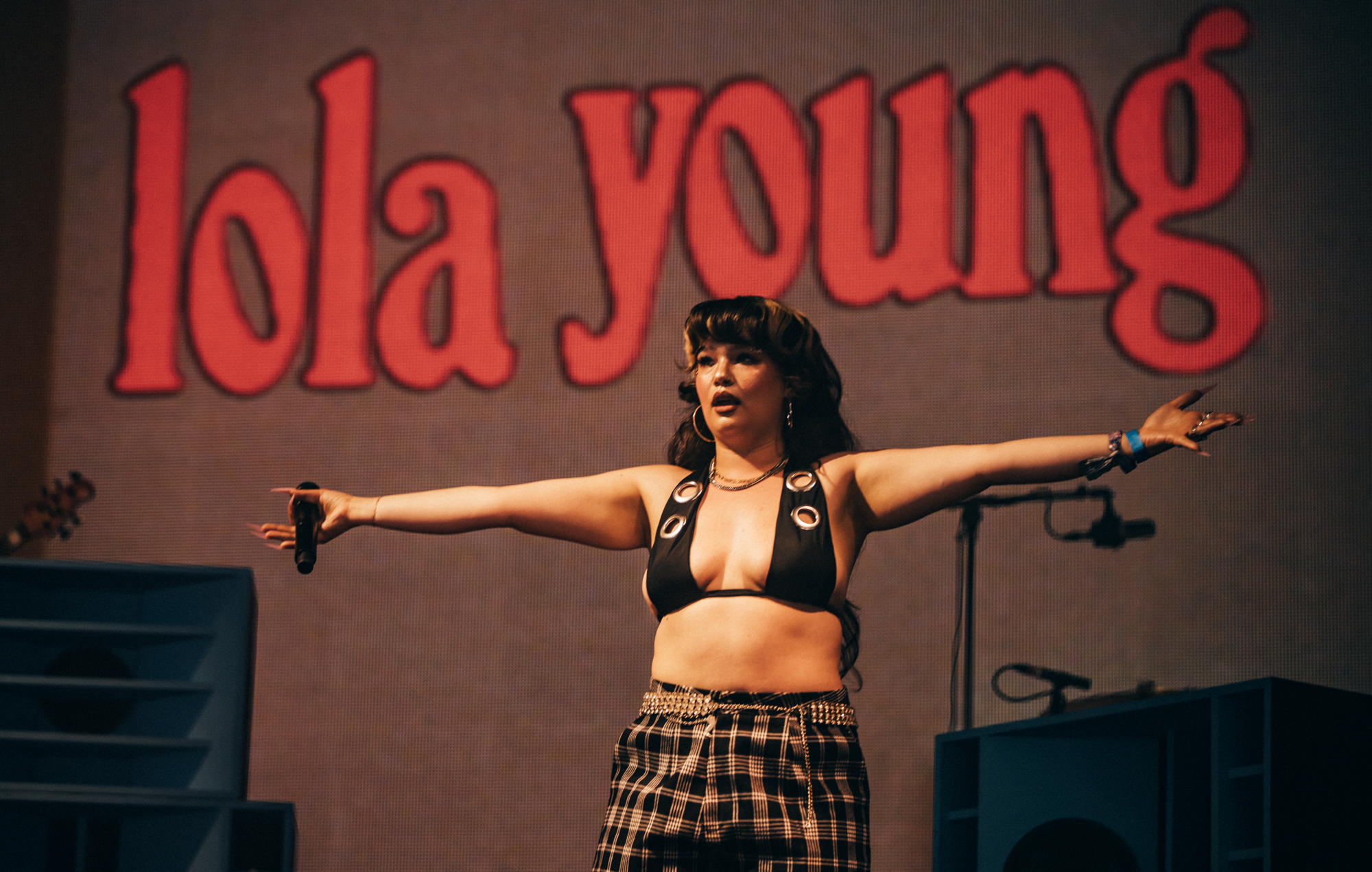 Lola Young performing on stage at a festival