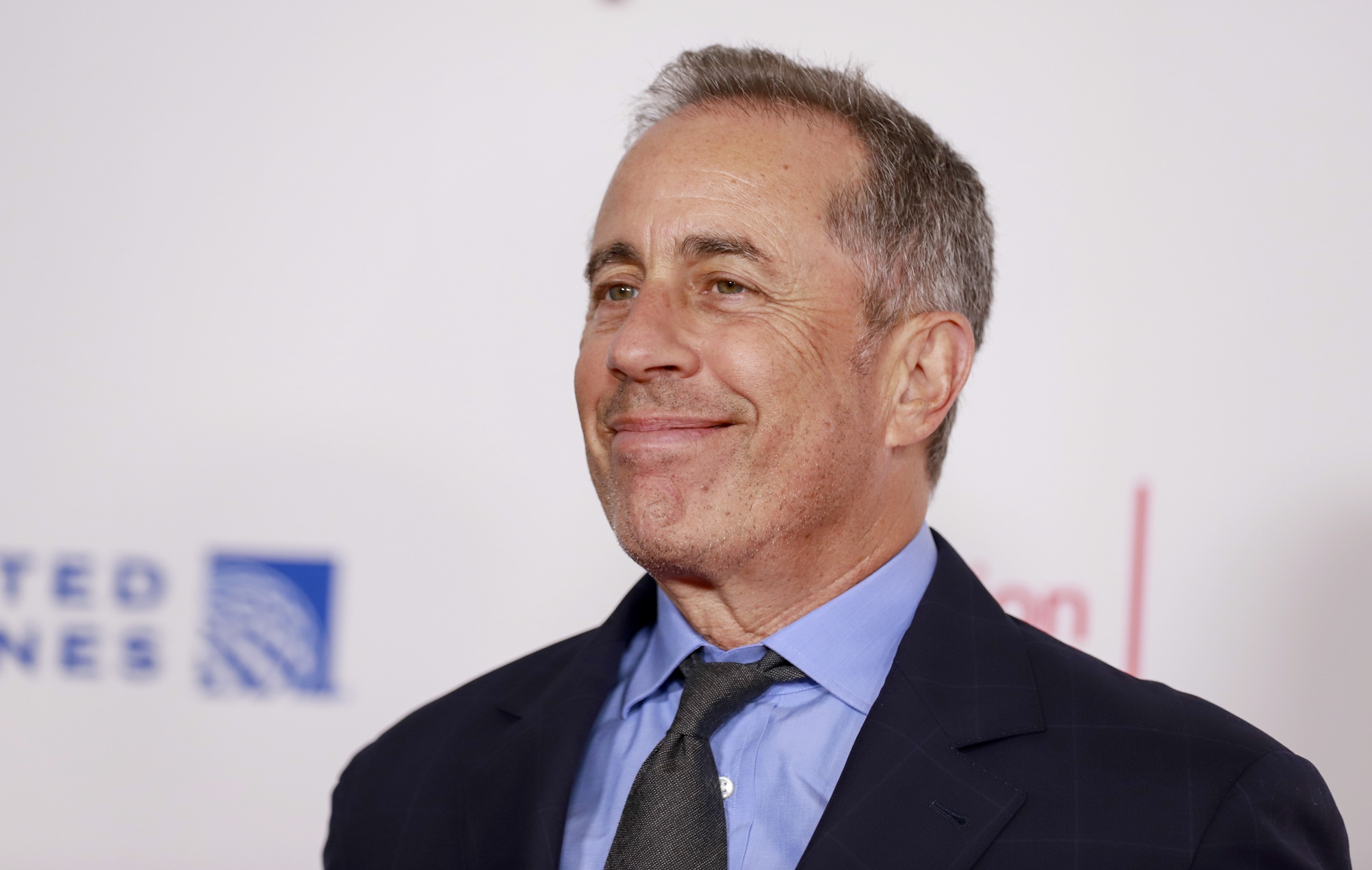 Jerry Seinfeld performing stand-up comedy on stage