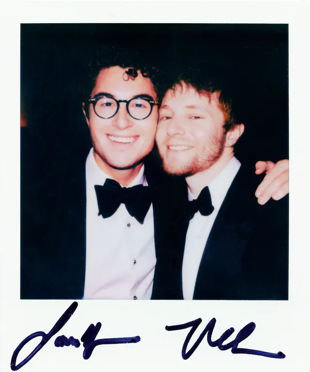 Image may contain Clothing Formal Wear Suit Face Head Person Photography Portrait Accessories Glasses and Tuxedo