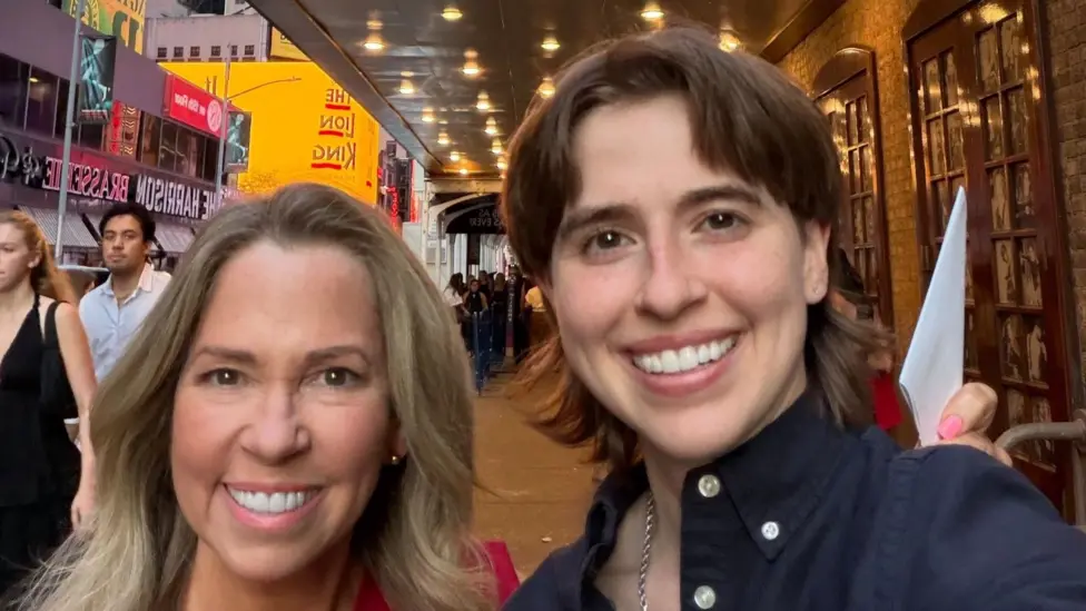Sealy Sikes (right) with her mum Tammy (left) on Broadway. Tammy has blonde hair and wears a pink dress, Sealy wears a blue shirt with a silver chain and has short brown shoulder length hair with a fringe