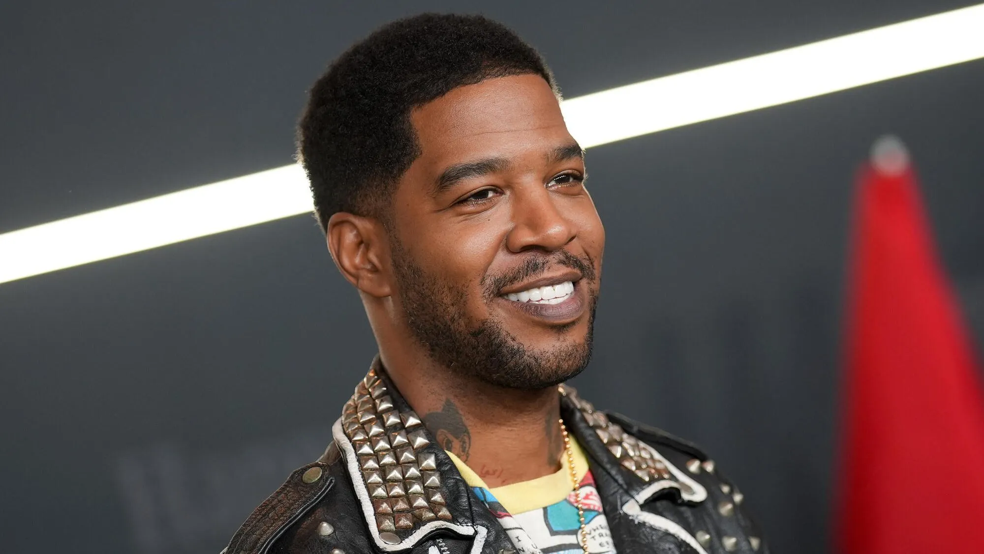 Kid Cudi attending a red carpet film premiere in a sleek outfit