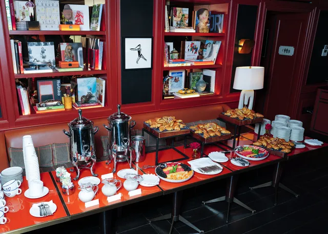 Image may contain Catherine of Aragon Brunch Food Cafeteria Indoors Restaurant Meal Shelf Person and Buffet