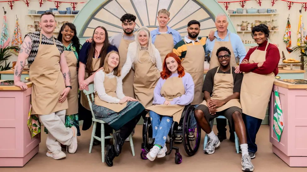 The twelve new Bake Off contestants pictured on the kitchen set - L-R Gabe, Nikki, Shannon, Danni, Mo, Clara, Tom, Molly, Yannis, Gary, Moyin, Connie