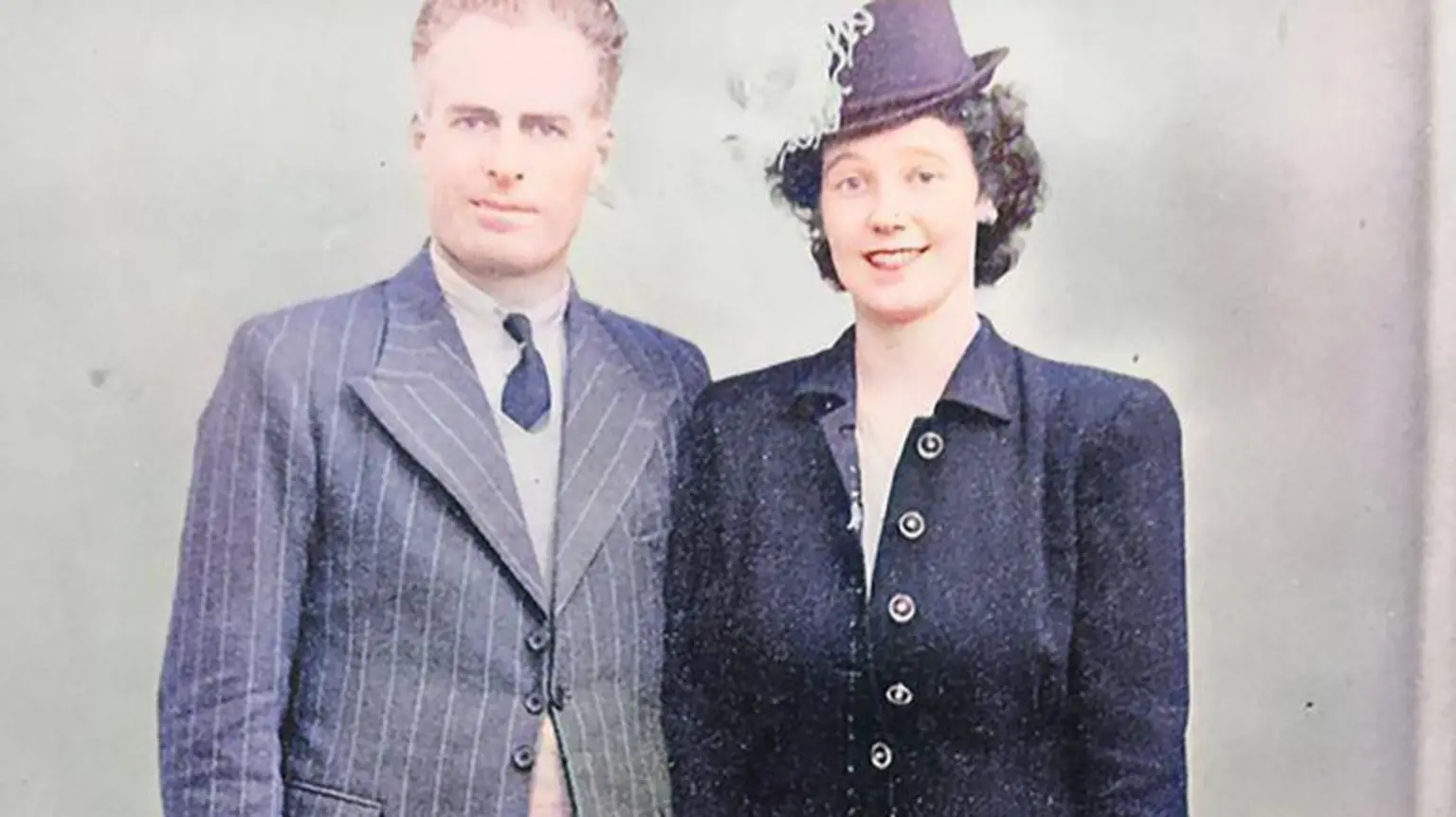 Ted and Maureen Sweeney in smart suits, smiling in a photo from 1946
