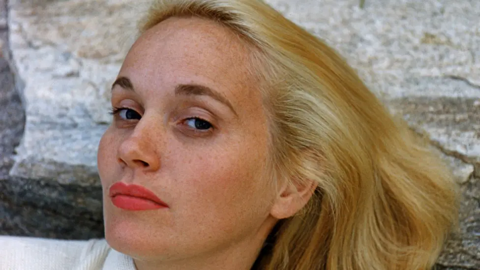 A headshot of Eva Marie Saint with blonde hair as she reclines on a rock in around 1960