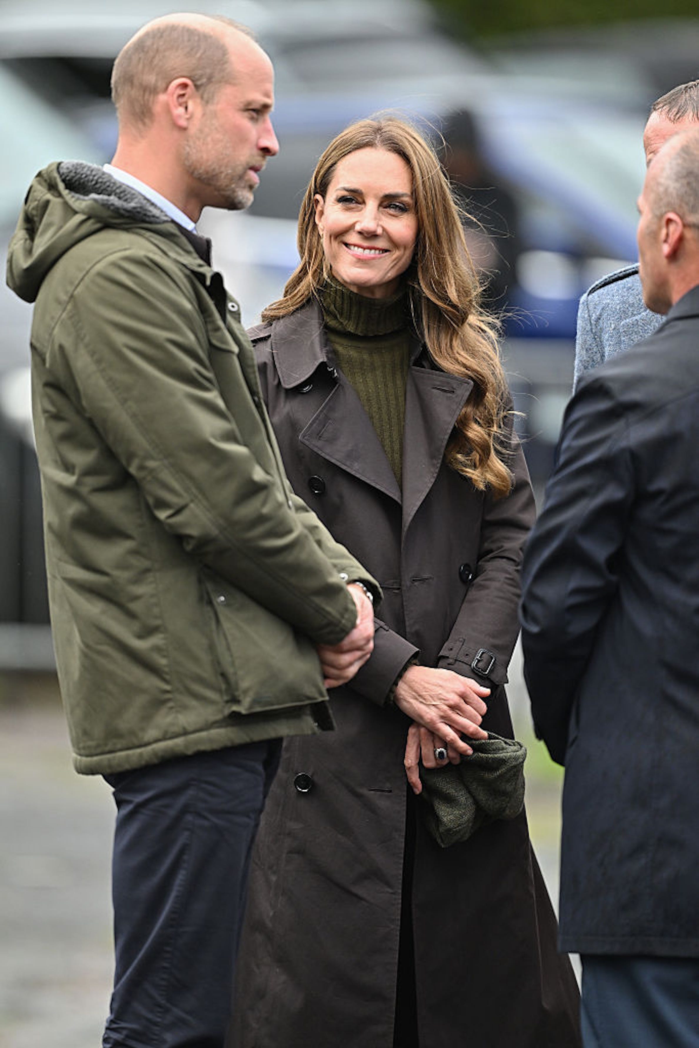 Prince William and Kate Middleton smiling together in matching earth tones during their trip to the Isle of Bute.