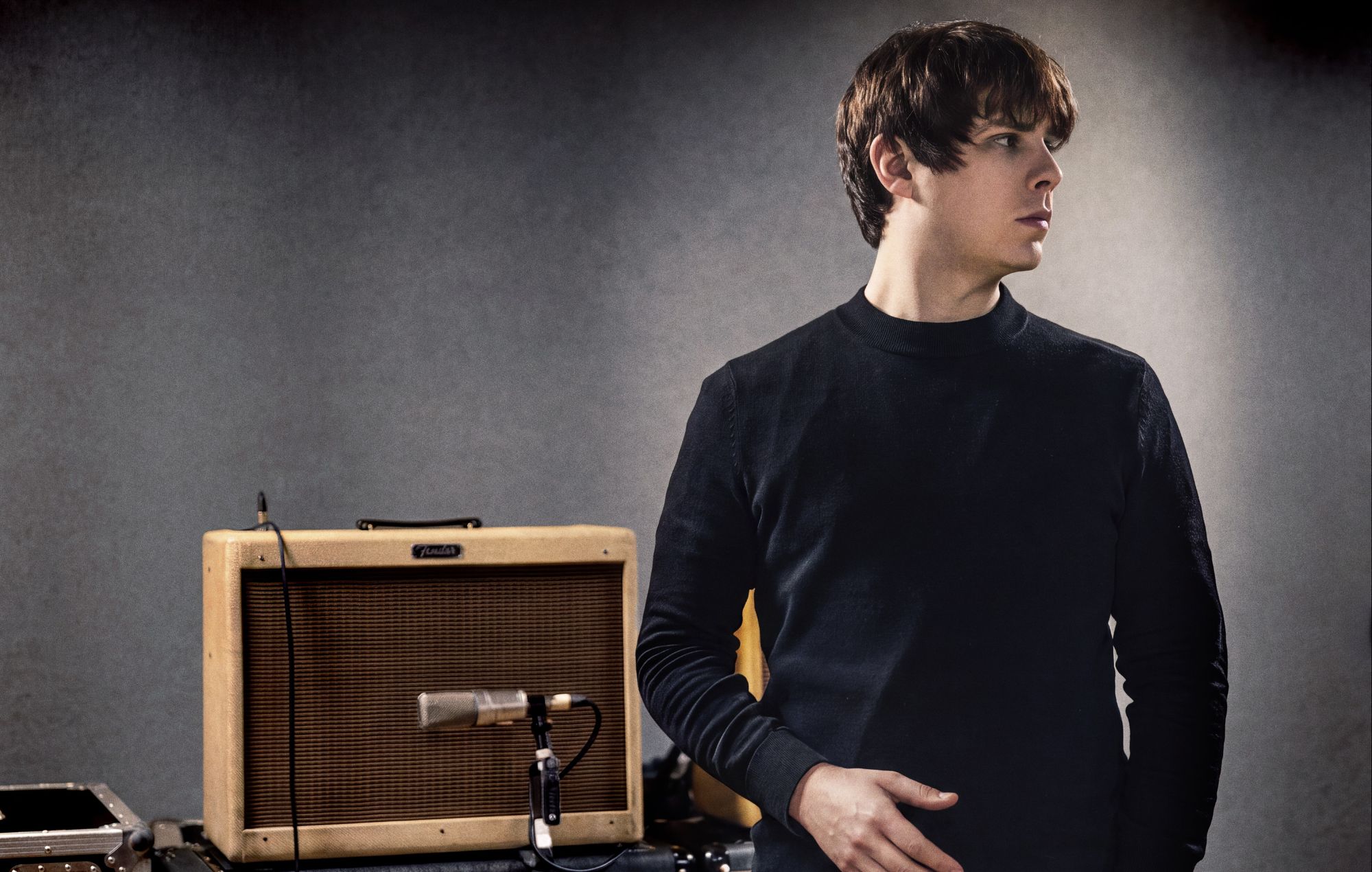 Jake Bugg performing live on stage with a guitar