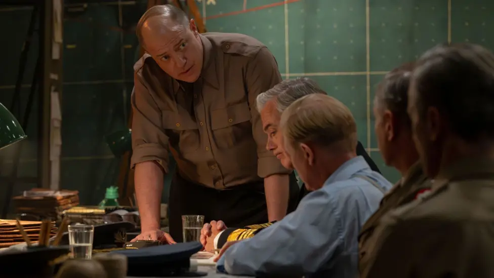 Brendan Fraser in uniform on the set of Pressure, he is leaning on a table looking tense
