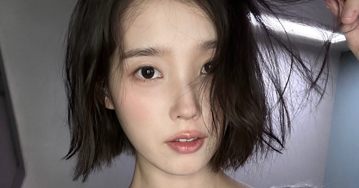 IU smiling as a guest at her hairstylist's wedding ceremony