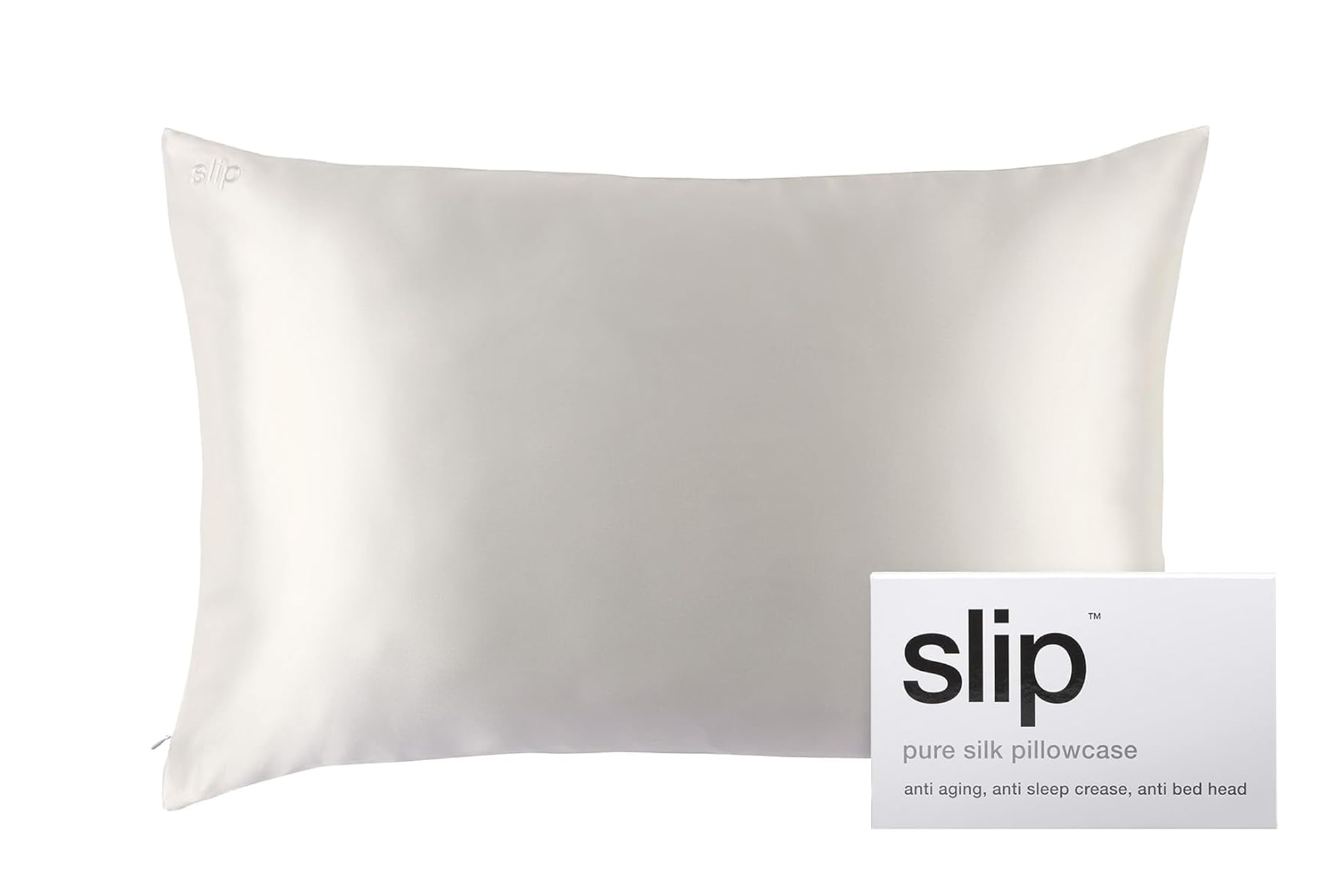 A cream-colored silk pillowcase with the word "slip" embroidered in the top left corner, next to a box for "slip pure silk pillowcase".