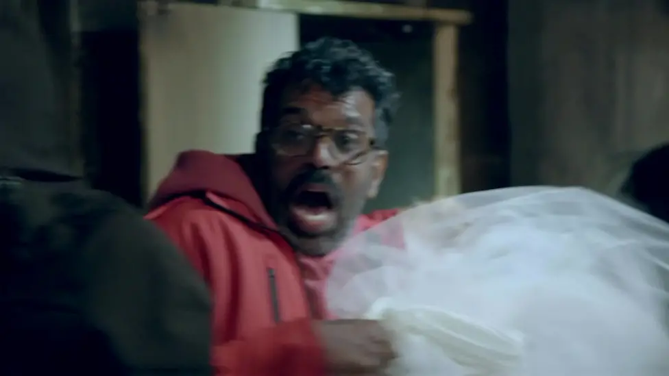 Romesh Ranganathan lets out a scream while salvaging a dead woman's wedding dress in the haunted cabin