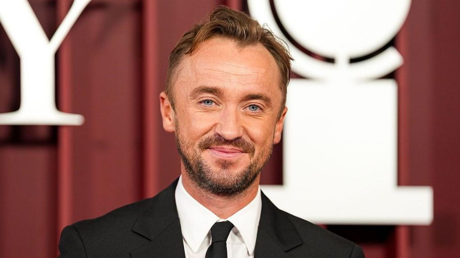 Tom Felton smiling at an entertainment industry event