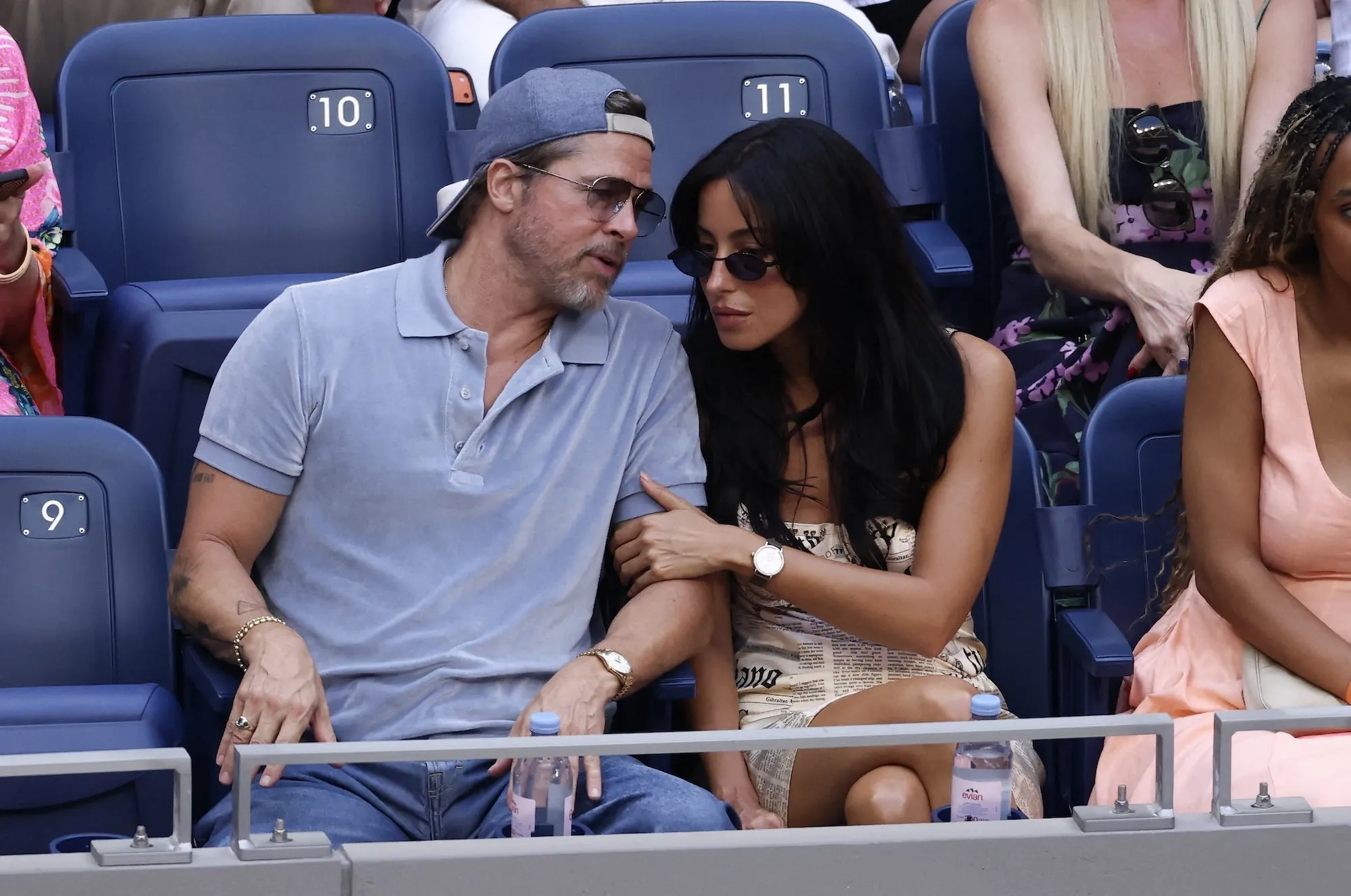 Brad Pitt and Ines de Ramon sitting together in the stands at the US Open