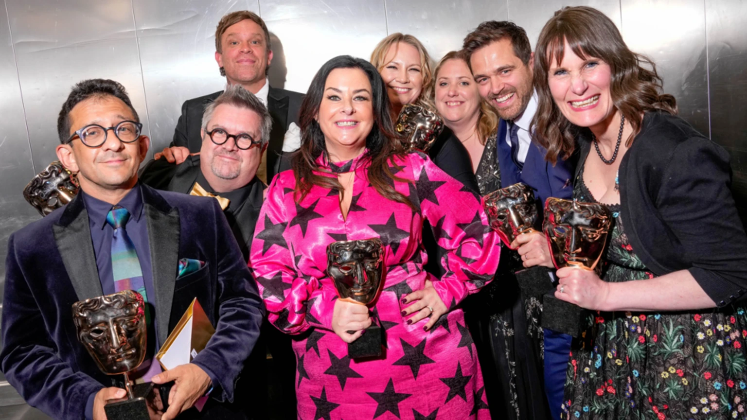 Jon Sen, William Beck, Liza Mellody, Michael Stevenson and Loretta Preece are photographed backstage at the BAFTA Television Awards. They are each holding an award, smiling and looking at the camera.