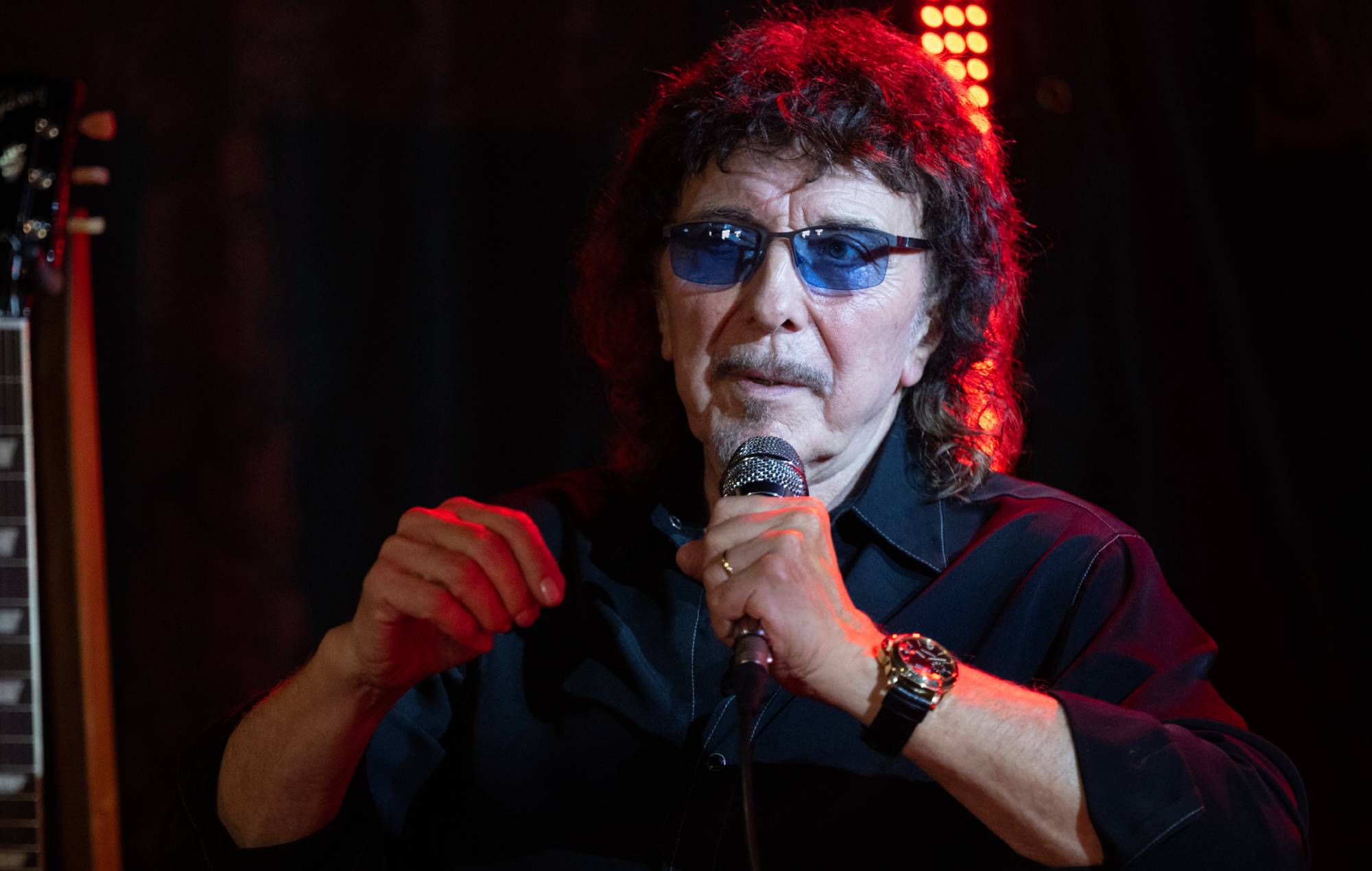 Tony Iommi playing guitar on stage during a concert