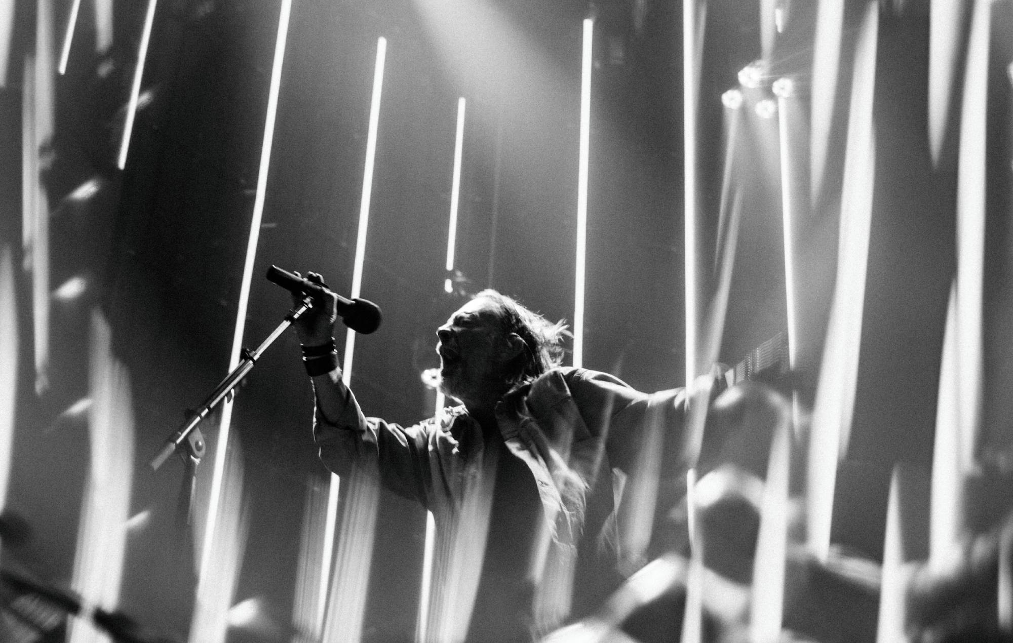 Radiohead performing live on stage under bright concert lights