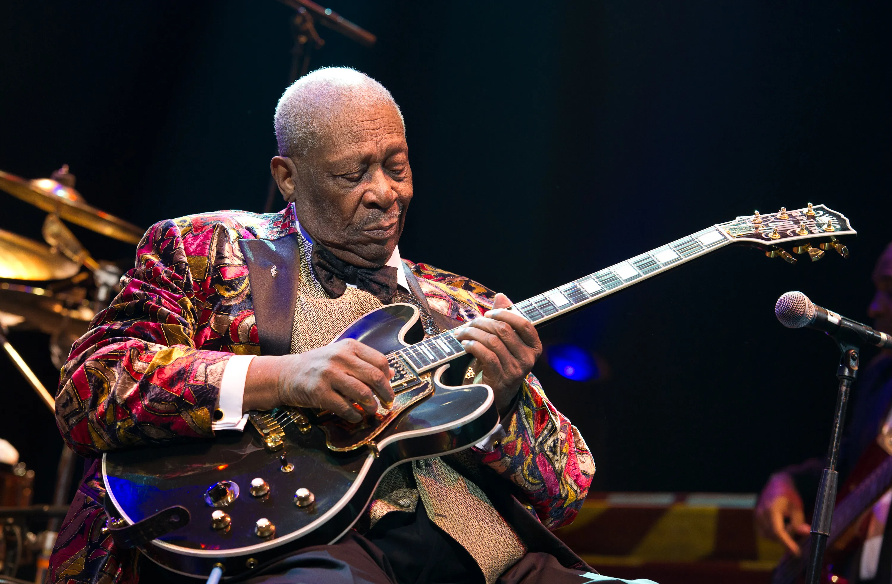 Blues icon B.B. King smiling while playing his electric guitar live on stage