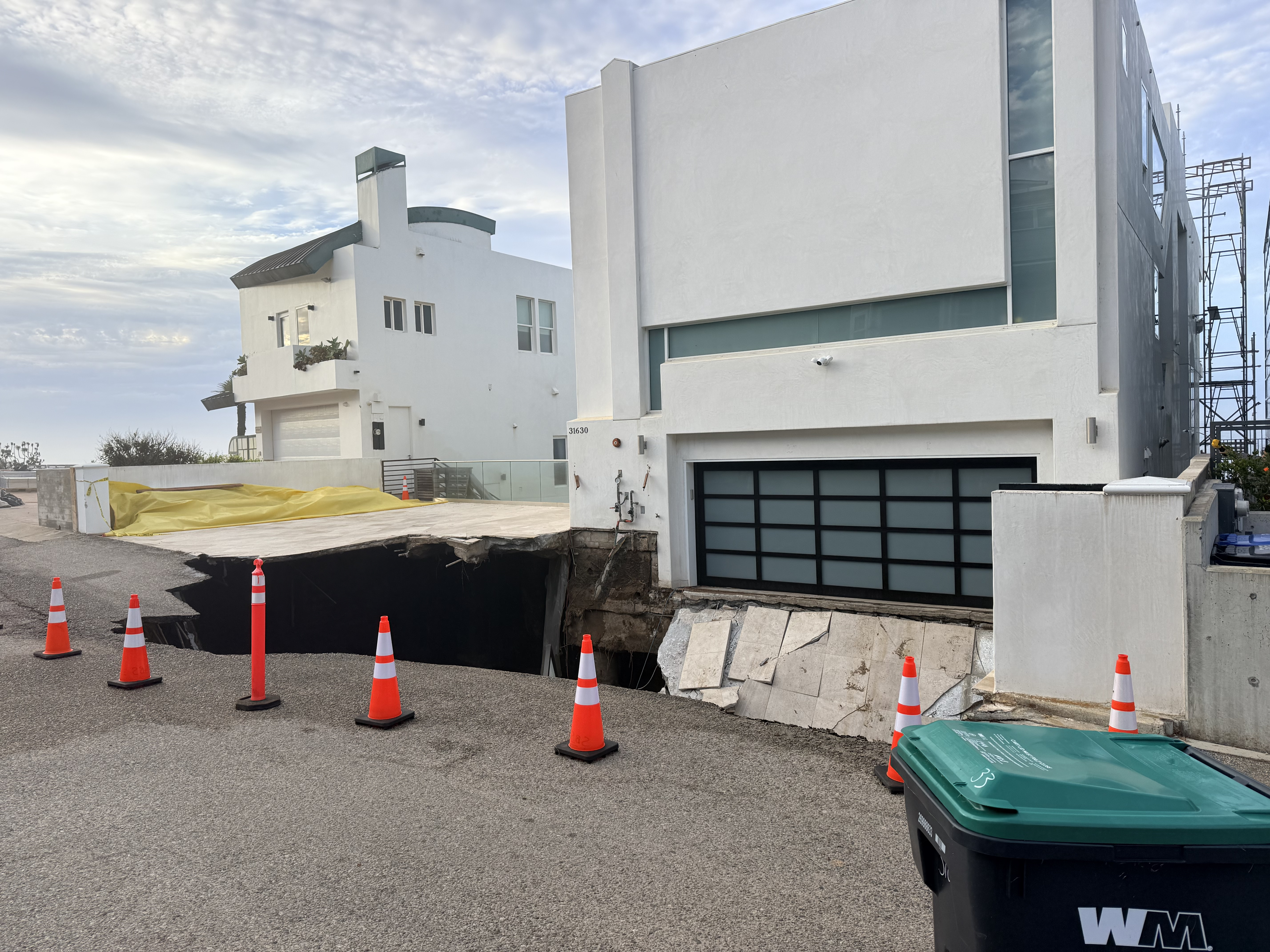 A Malibu beach house at 31630 is at risk of falling into the Pacific Ocean due to extreme erosion, with its driveway and adjacent road collapsing into a sinkhole.