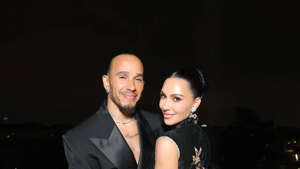 Kim Kardashian and Lewis Hamilton posing in coordinated red carpet fashion outfits
