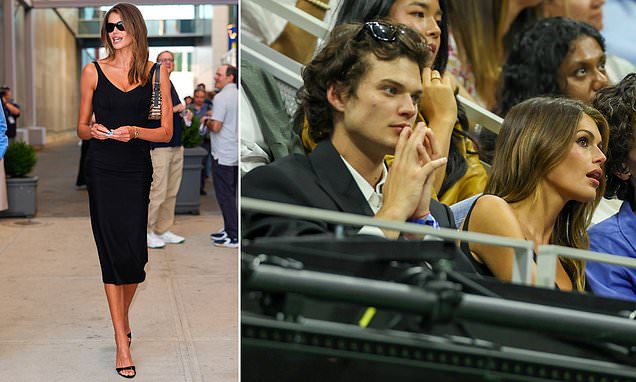 Kaia Gerber sitting in the stands at the US Open in a little black dress