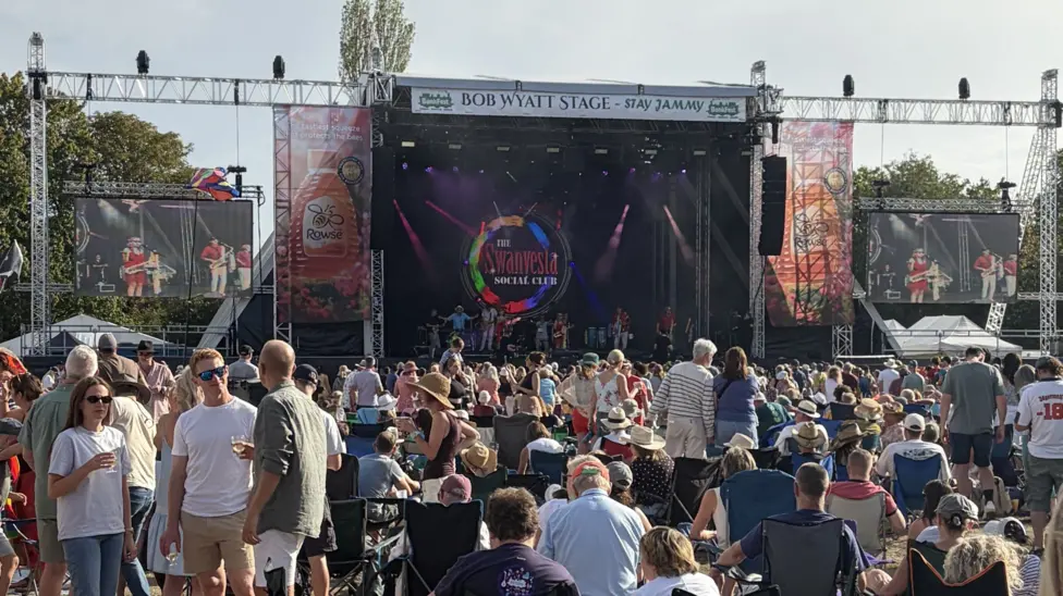The stage of BunkFest, with screens either side, and a large crowd watching on.