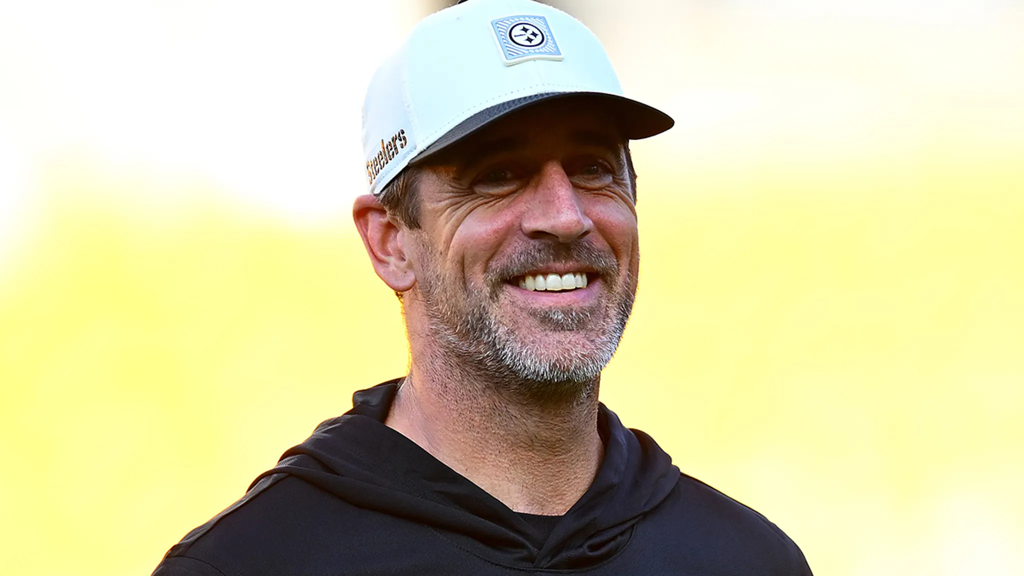 Aaron Rodgers speaking into a microphone during a radio interview