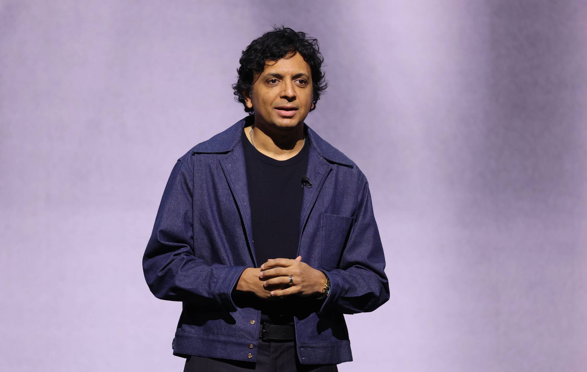 Director M. Night Shyamalan posing with Charli XCX and his daughter Saleka backstage at a concert
