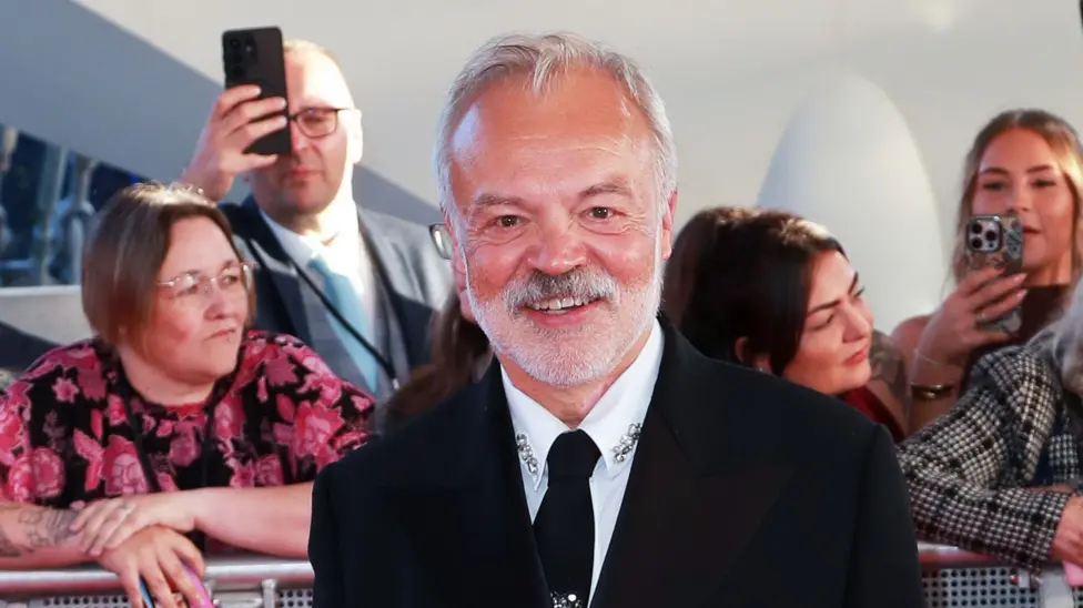 Graham Norton smiles as he stands on the National Television Awards red carpet