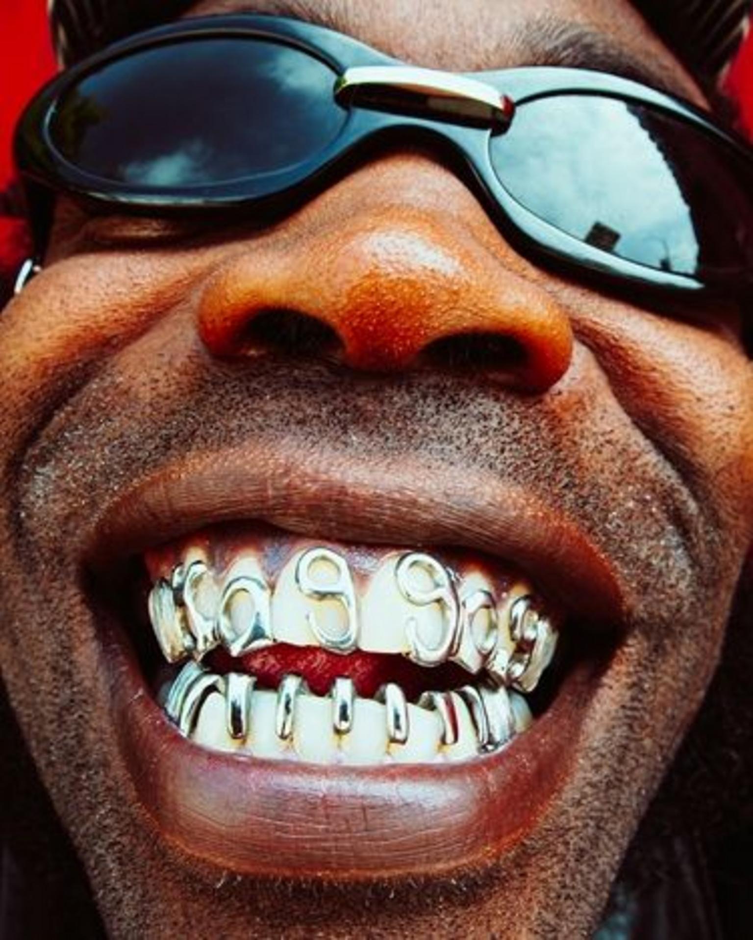 The OGM from New York rap duo HO99O9, grinning while showing off his grills