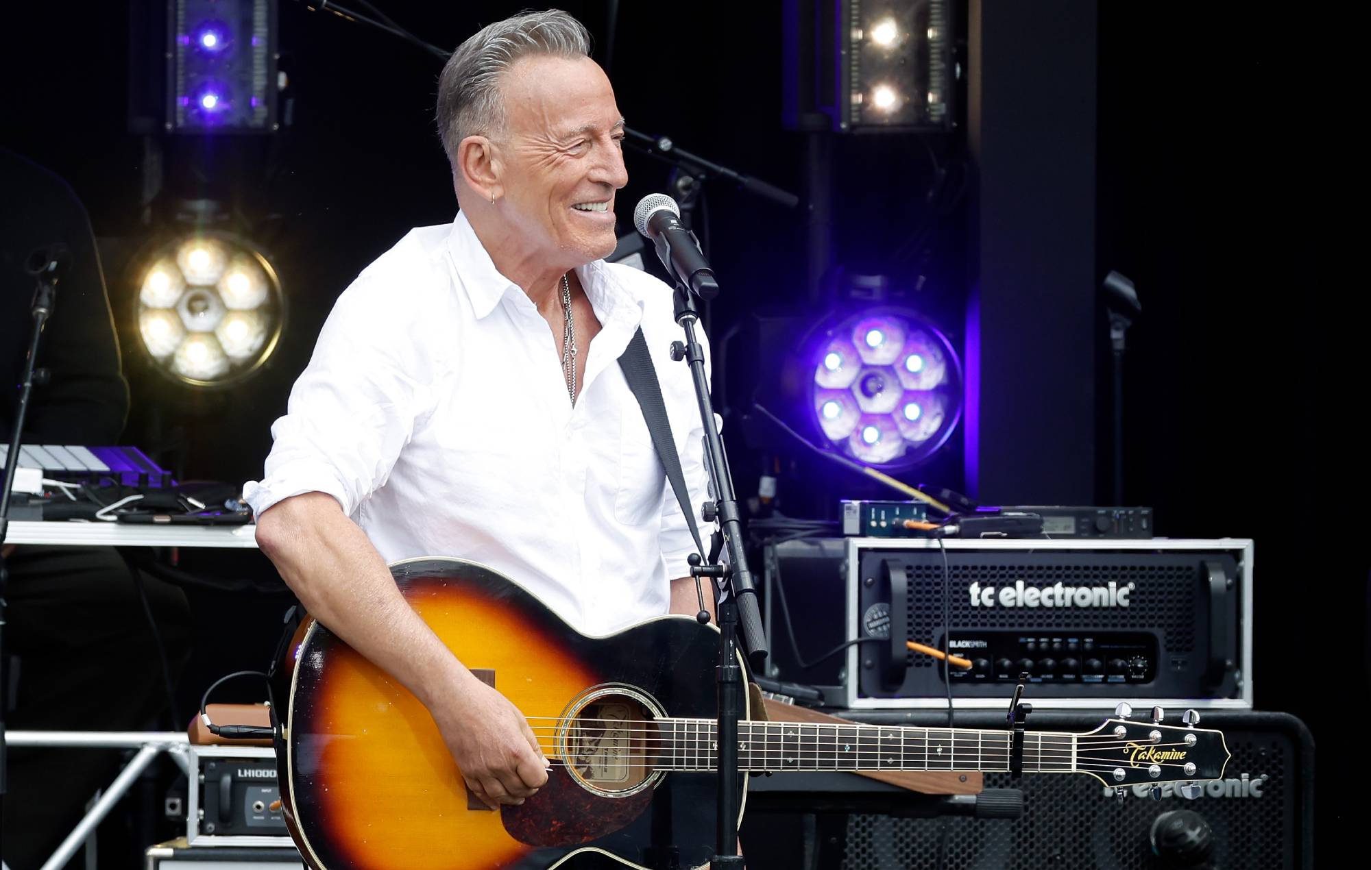 Bruce Springsteen performing live on stage with a guitar