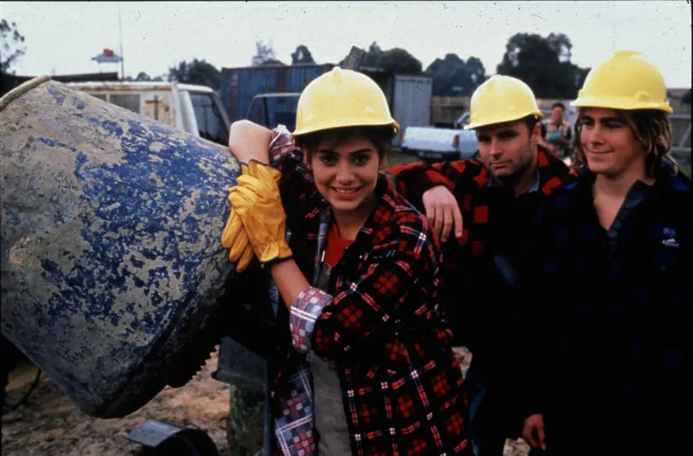 Natalie Imbruglia leans against a concrete mixer in a promotional photograph for the TV show Neighbours