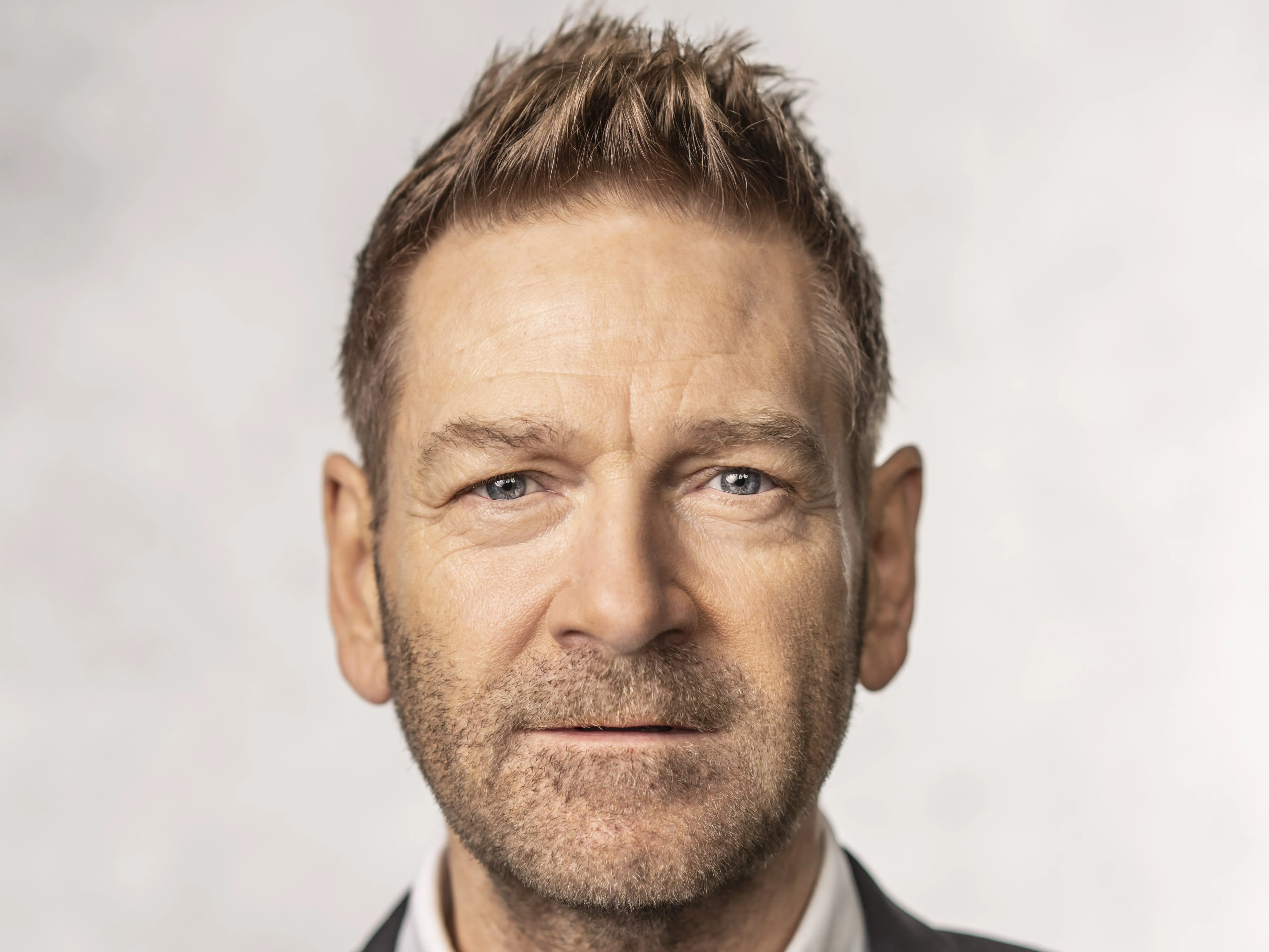 Kenneth Branagh speaking on stage at a film festival retrospective event