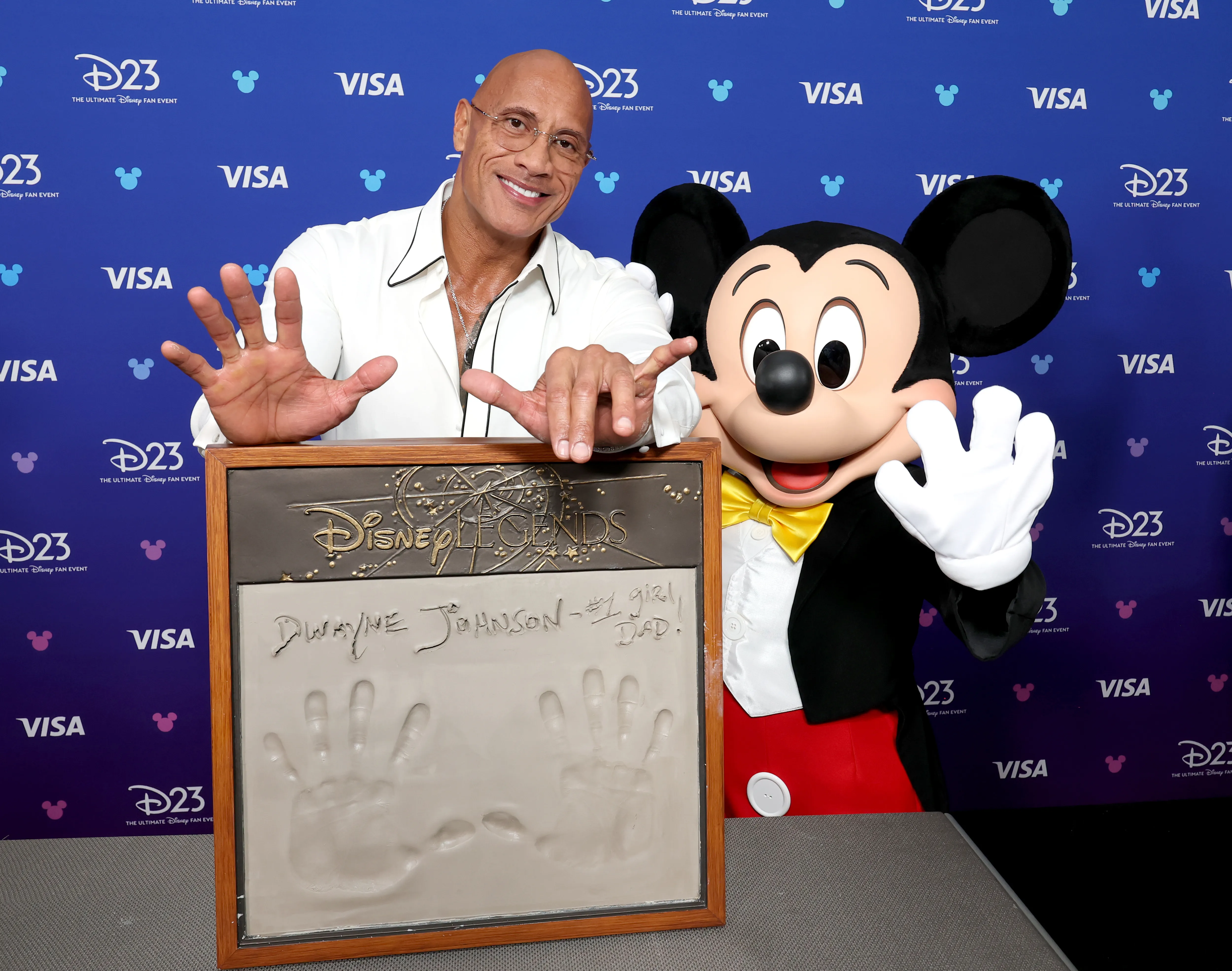 ANAHEIM, CALIFORNIA - AUGUST 16: Dwayne Johnson gets his handprints with Mickey Mouse at the Disney Entertainment Showcase at D23: Legends on August 16, 2026 in Anaheim, California. (Photo by Kevin Mazur/ for