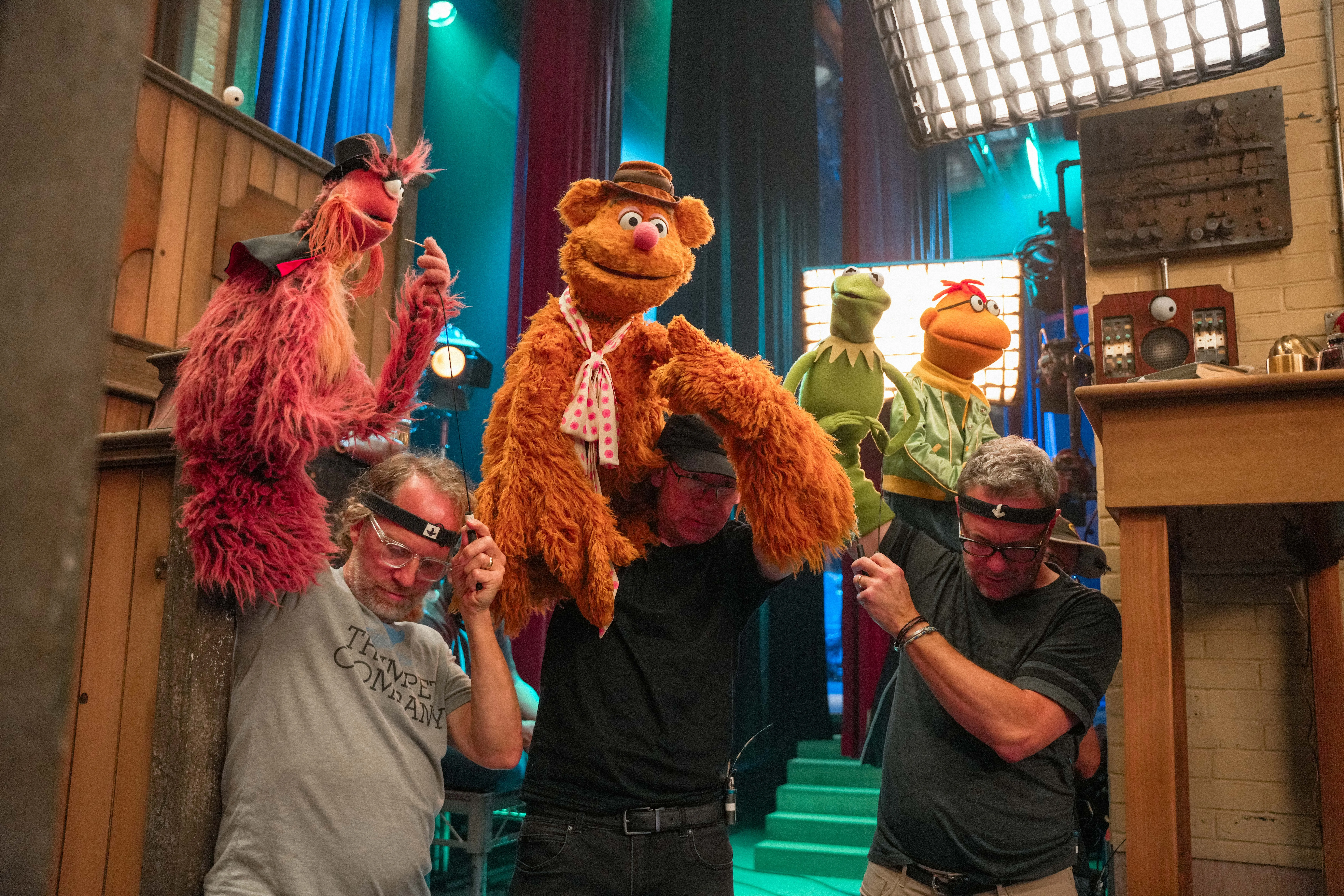 Kermit the Frog performing on stage in the restored Muppet Theatre for a Disney special.