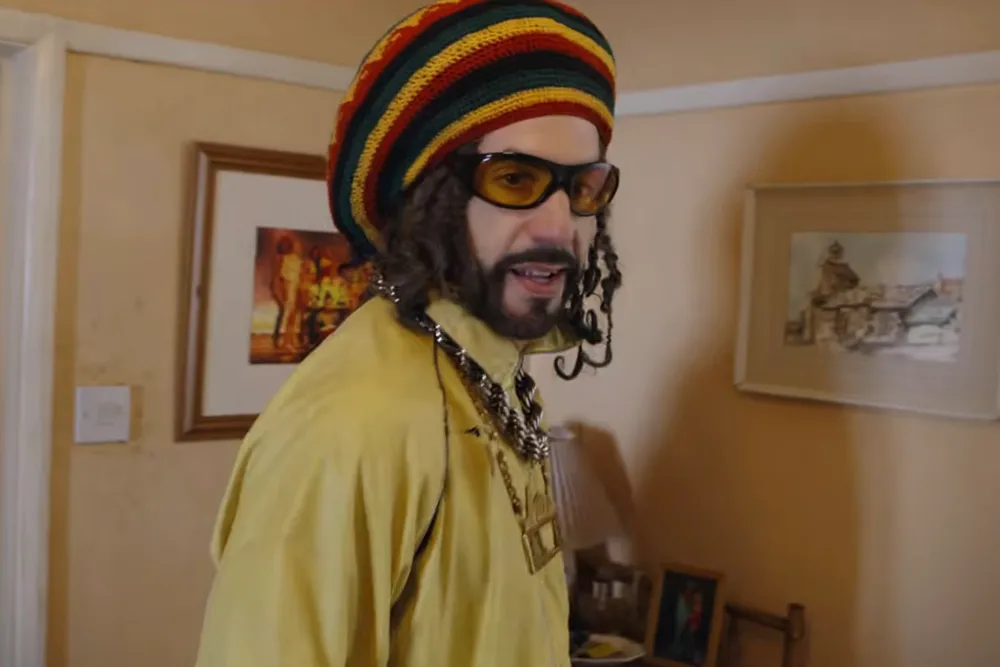 Sacha Baron Cohen dressed in his iconic yellow tracksuit and sunglasses as Ali G