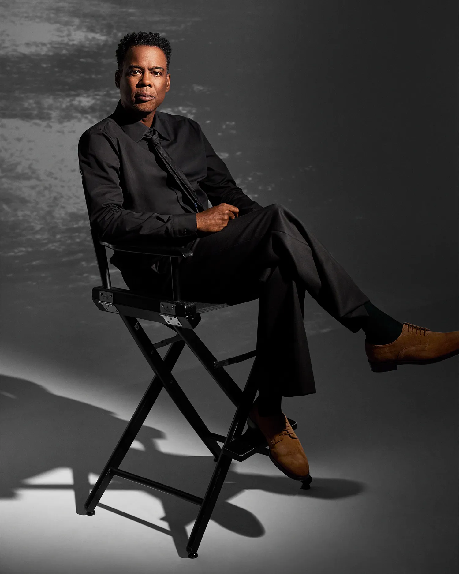 Chris Rock speaking thoughtfully during a press appearance