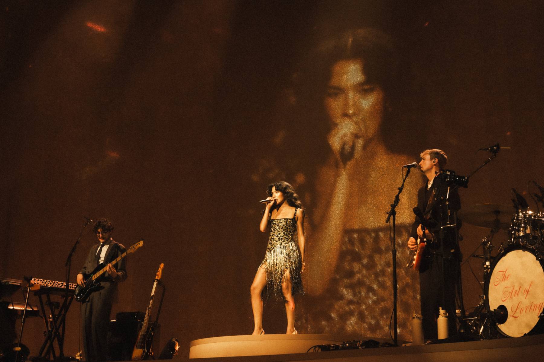 Olivia Dean performing live on stage during her headlining concert tour