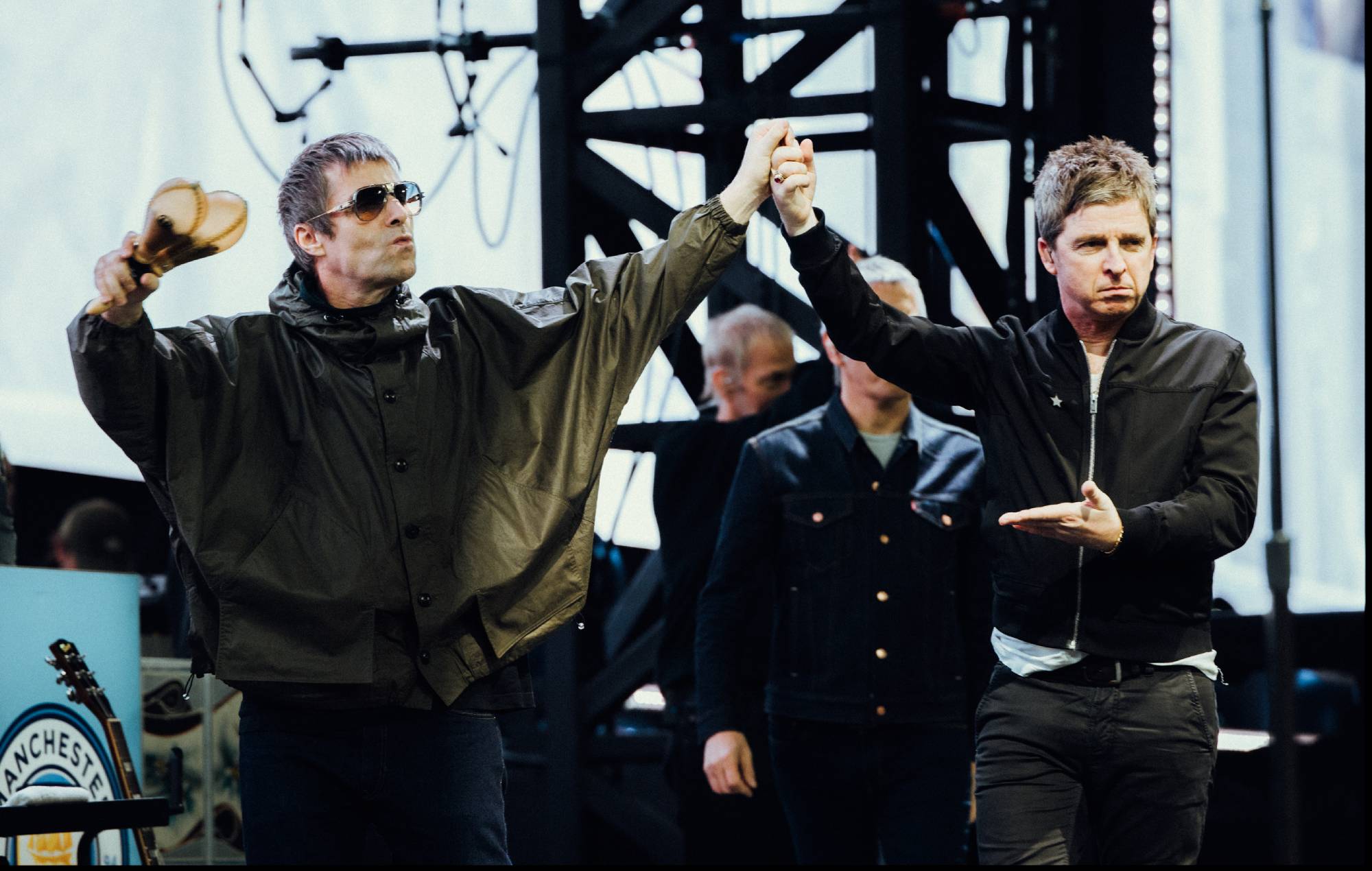 Oasis performing live on stage during a massive stadium concert