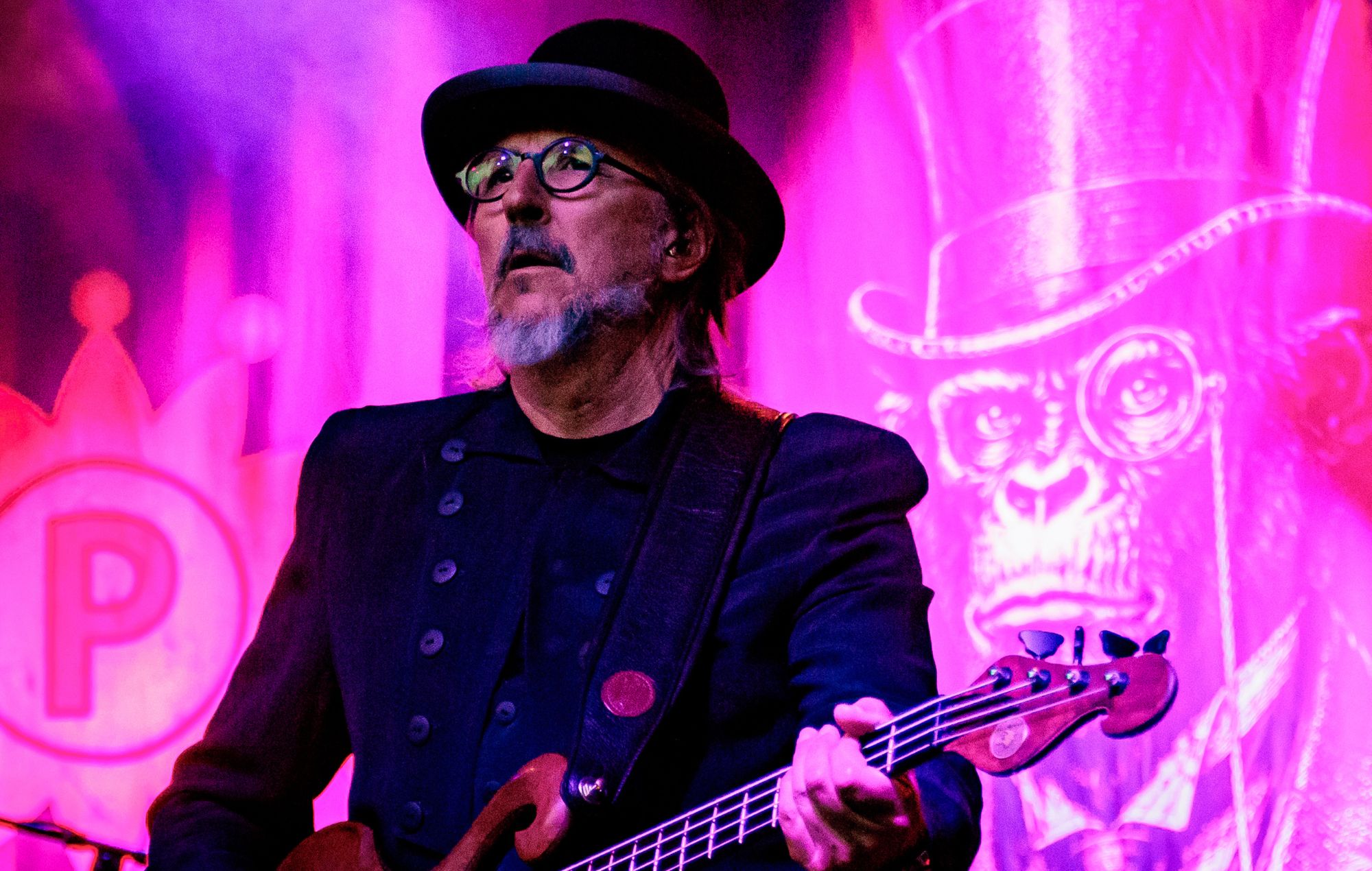 Les Claypool performing live on stage with his bass guitar